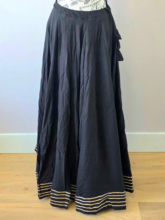 Black skirt on a mannequin against a plain wall.